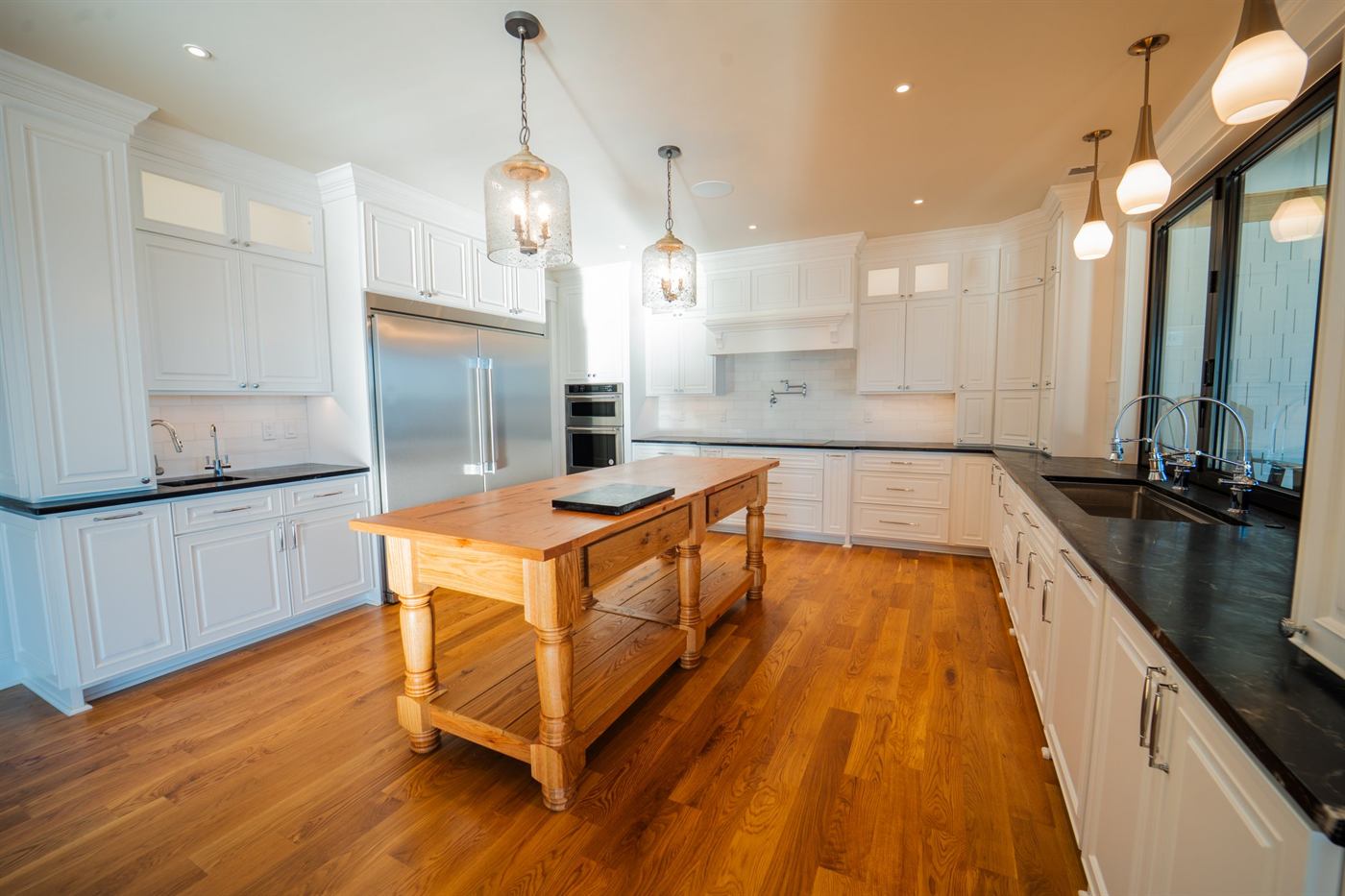 Kitchen in a custom lake house, with white millwork and a wood island