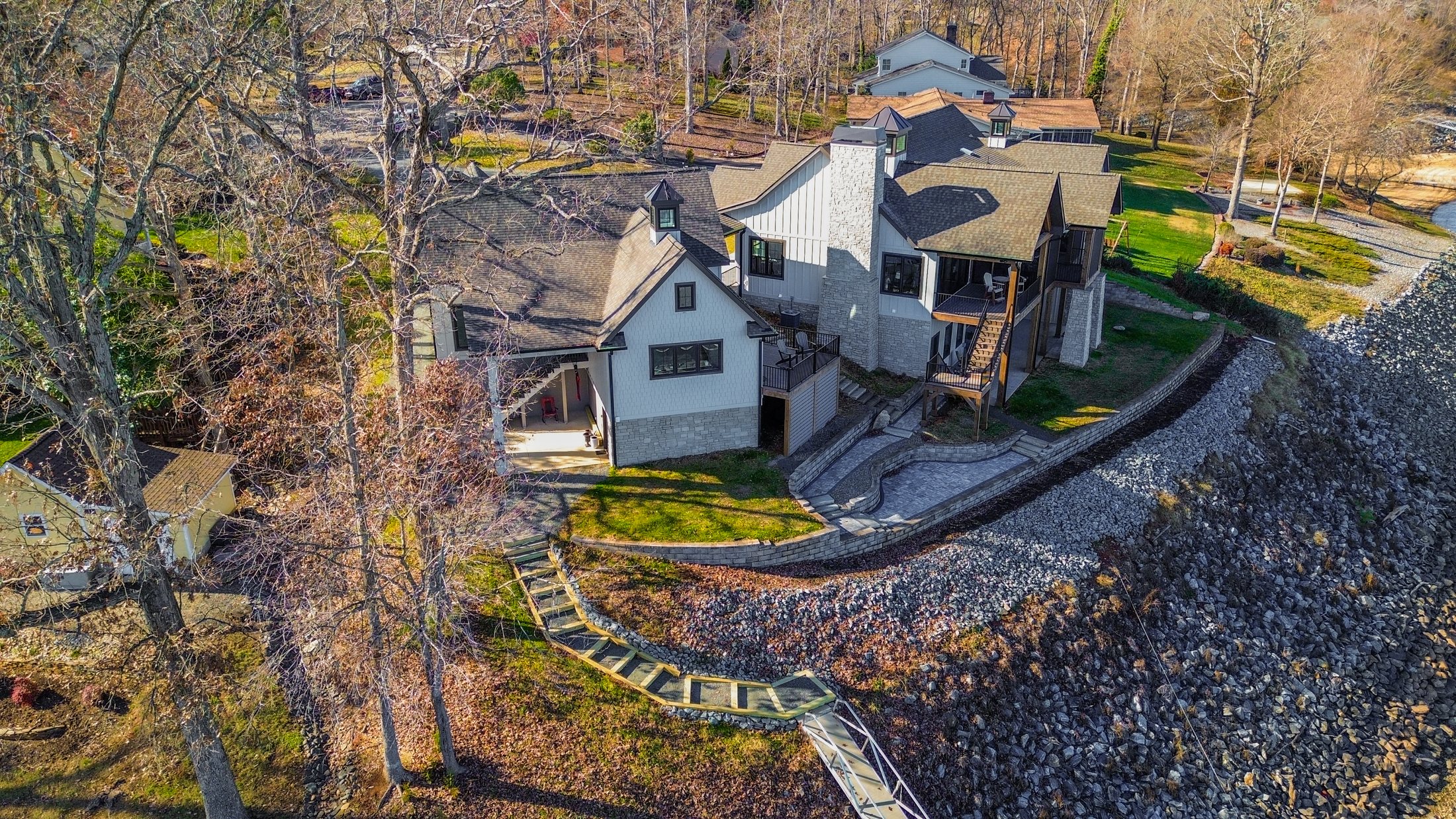 Aerial of House on the lake along the shoreline with dock walk