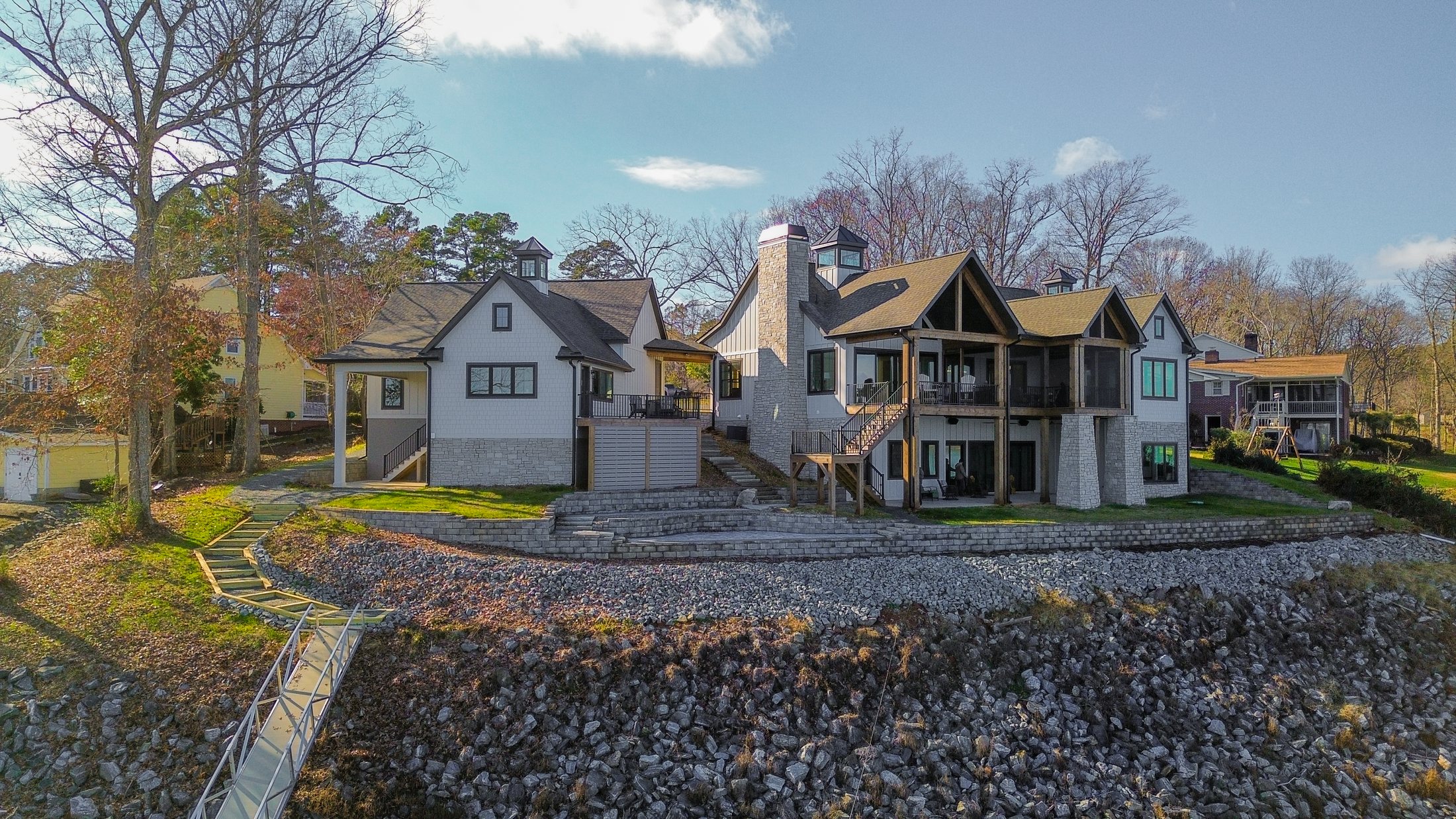 House on the lake water elevation with stone terrace and screened porch