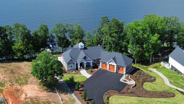 Aerial of a lake house with a cupola and wood garage doors